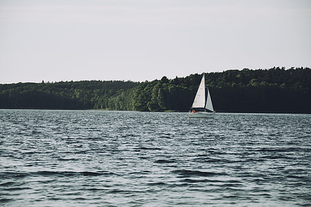 white sailboat in the sea during cloudy day thumbnail