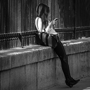 woman using smartphone leaning on wall thumbnail