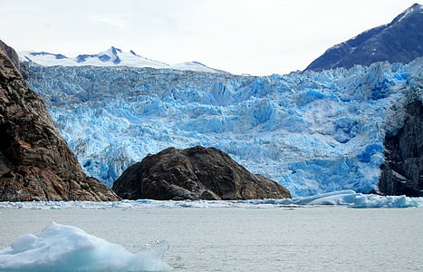 mountain covered with ice near black cliff thumbnail