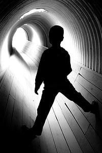 silhouette of boy standing at tunnel thumbnail
