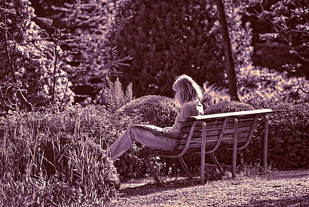 woman sitting on bench near garden thumbnail