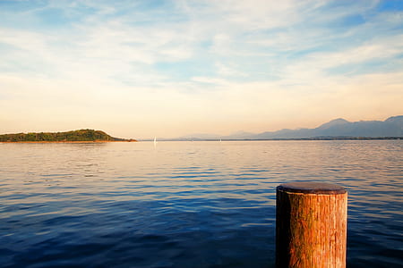 photo of body of water under golden sky thumbnail