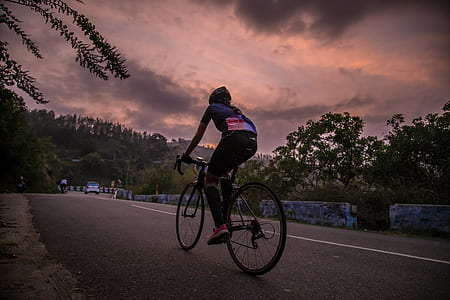 man riding on bicycle on concrete road thumbnail