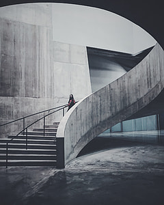 woman in red top talking on concrete stairs inside building thumbnail