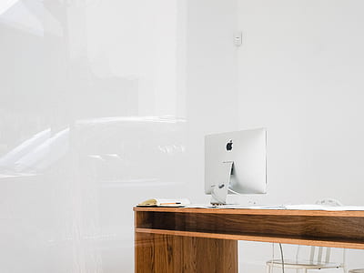 silver iMac on desk near wall thumbnail