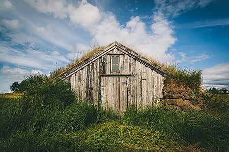 brown wooden storage house surrounded by green grass thumbnail