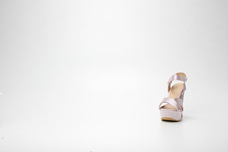 unpaired white leather sandal on white surface thumbnail