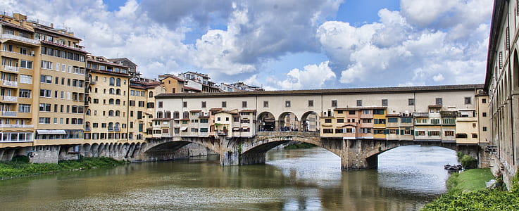 gray concrete bridge near yellow buildings during daytime thumbnail
