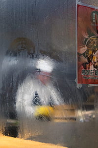 red kanji script poster taped on clear glass wall thumbnail