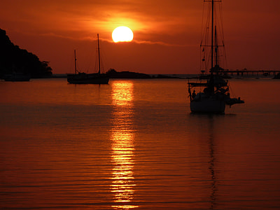 silhouette view of boat on body of water thumbnail