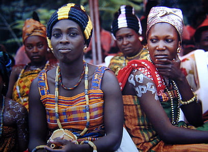women sitting near brown pole thumbnail