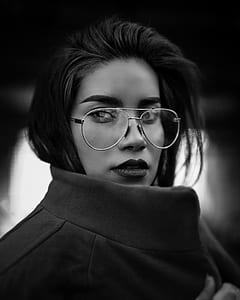 grayscale photo of woman in coat with aviator-style eyeglasses thumbnail