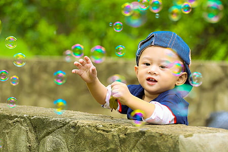 boy standing besides ledge looking at bubbles thumbnail