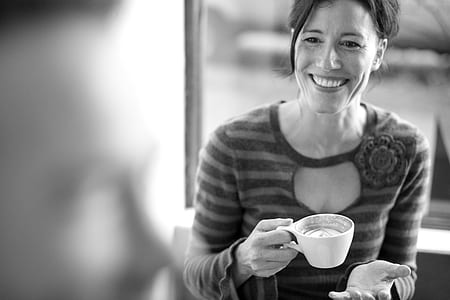 grayscale photo of woman holding teacup while smiling thumbnail