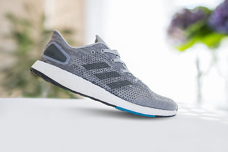 selective focus photography of unpaired grey and white adidas shoe on white surface thumbnail