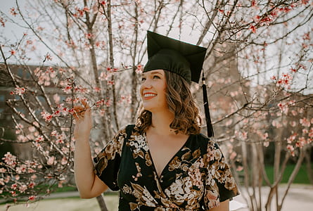 woman standing in front pink leaved tree thumbnail