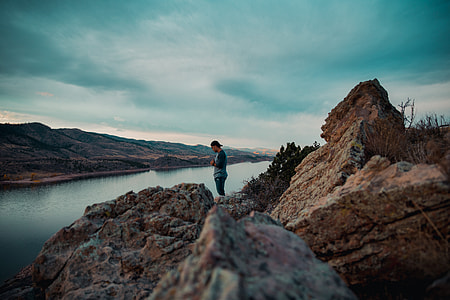 man near mountain cliff under blue sky thumbnail