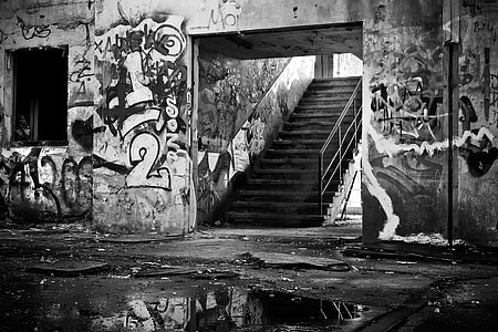 grayscale photography of stair beside wall full of graffiti thumbnail