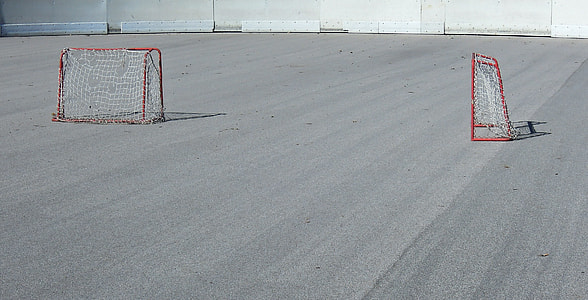 two red goalies on gray pavement thumbnail