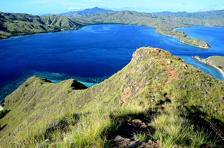 landscape photography of lake surrounded by green mountains at daytime thumbnail