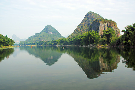 body of water in between green mountains at daytime thumbnail