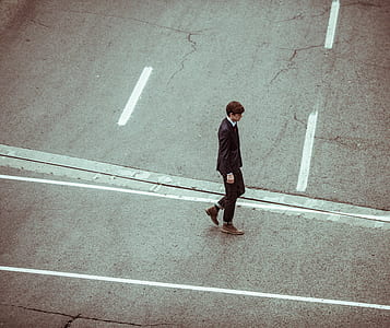 man wearing brown boots walking on road thumbnail