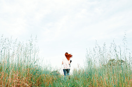 woman standing on green grass field during daytime thumbnail