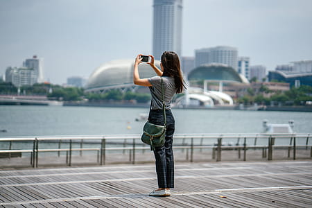 Woman Standing Taking Picture of Scenery thumbnail