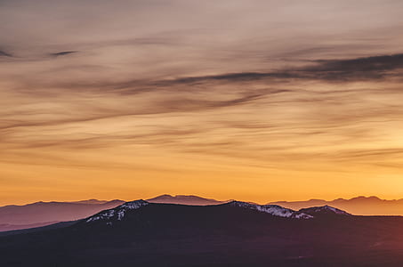 silhouette photo of mountain under orange sky during golden hour thumbnail