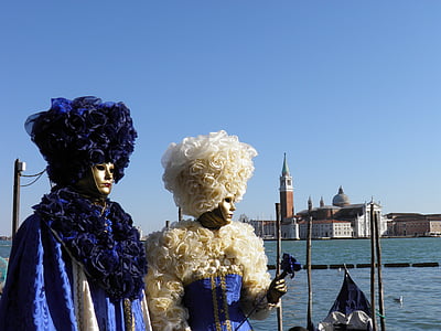 two persons wearing mask standing near body of water thumbnail