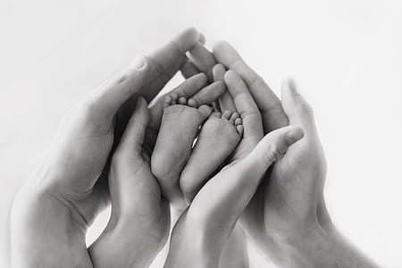 grayscale photo human hands and baby feet thumbnail