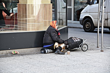 woman sitting beside road with trolley thumbnail
