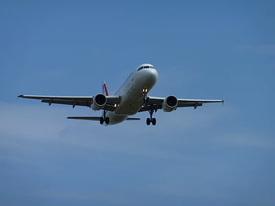 white airplane flying under white clouds thumbnail