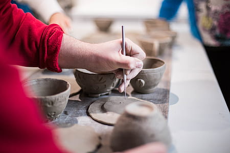 person sculpturing cup and saucer from clay thumbnail