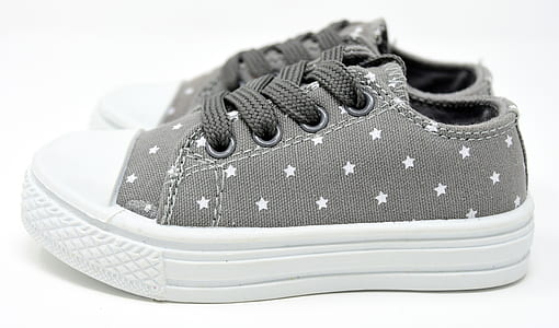 selective focus photo of gray-and-white star print low-top lace-up sneakers on white surface thumbnail