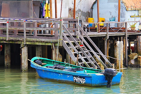green and blue boat beside dock during daytime thumbnail