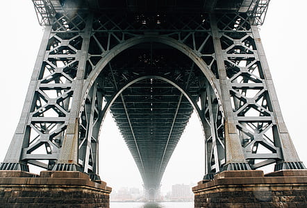 low-angle photography of gray metal bridge under gray sky during daytime thumbnail