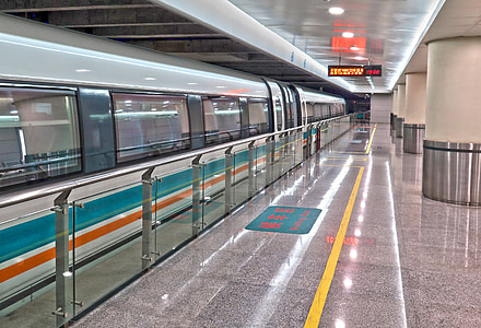 white, teal, and orange train at train station thumbnail