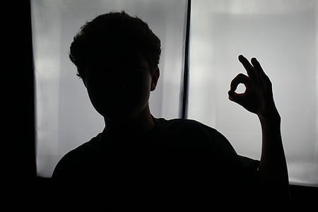 boy gesturing ok near glass window thumbnail