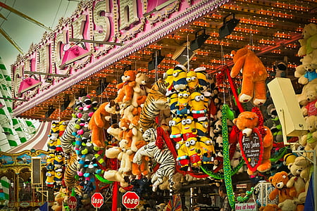 assorted plush toys hanging on LED signage thumbnail