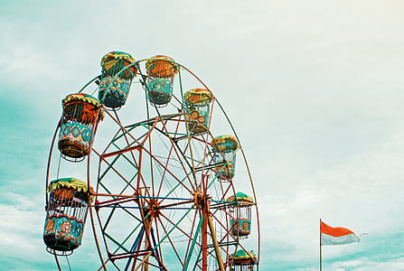 Photography of Orange Ferris Wheel Beside White and Orange Flag thumbnail