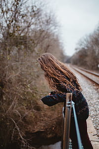 woman looking below leaning on bridge rails thumbnail