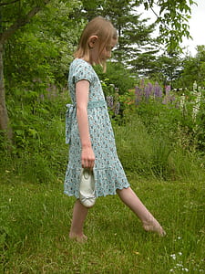 girl walking on lawn during day time thumbnail