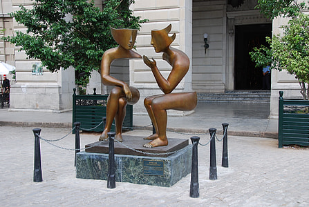 person taking photo of optical illusion statue thumbnail