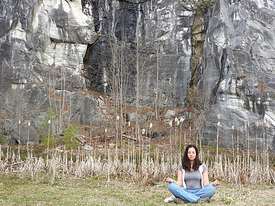 woman meditating beside rock mountain thumbnail