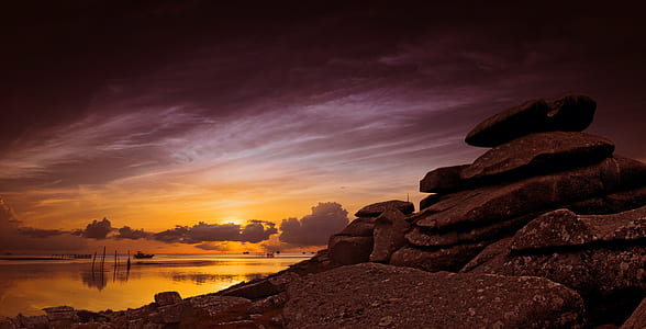 stack of stone overlooking body of water at sunset thumbnail