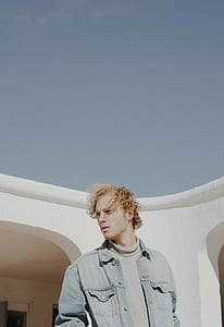 man standing near white painted wall thumbnail