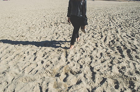 woman walking barefoot on sand thumbnail