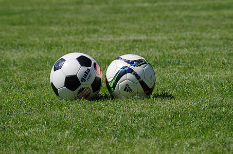 close up photography of soccer balls on green grass field thumbnail