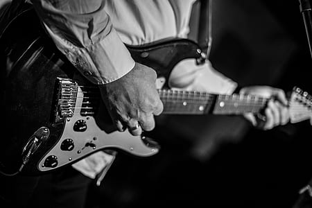 grayscale photography of man playing electric guitar thumbnail